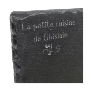 gravure du nom d'un restaurant sur une assiette en ardoise carrée